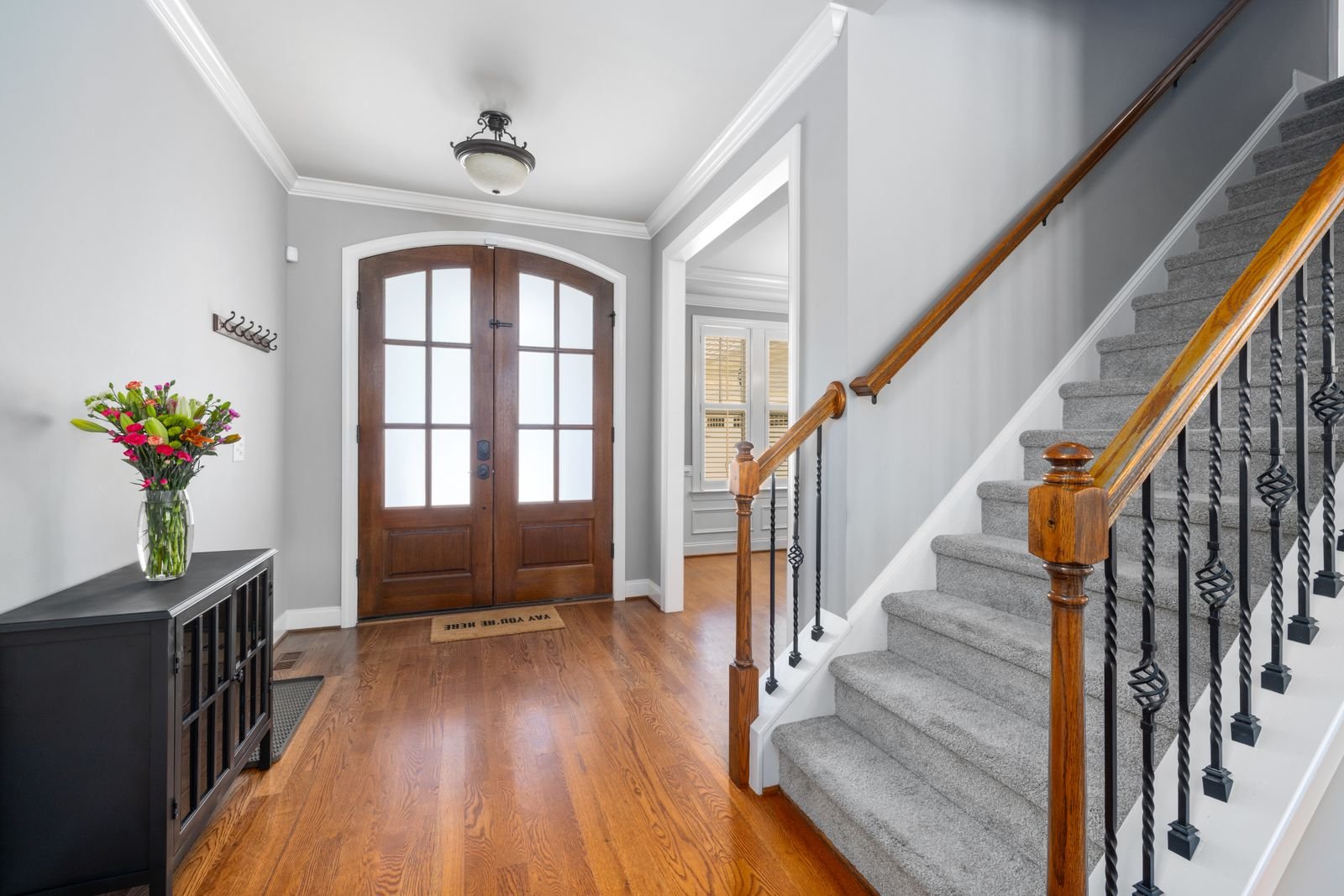 A carpeted staircase rising from a shared entrance hallway