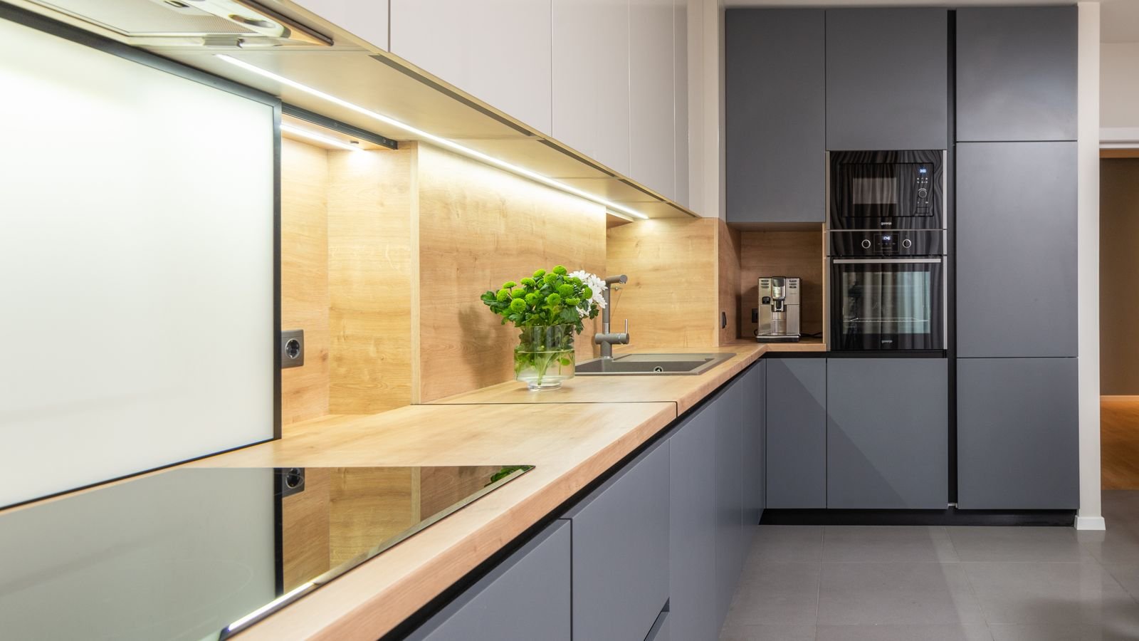Spotless kitchen hob and worktop with a glass splashback