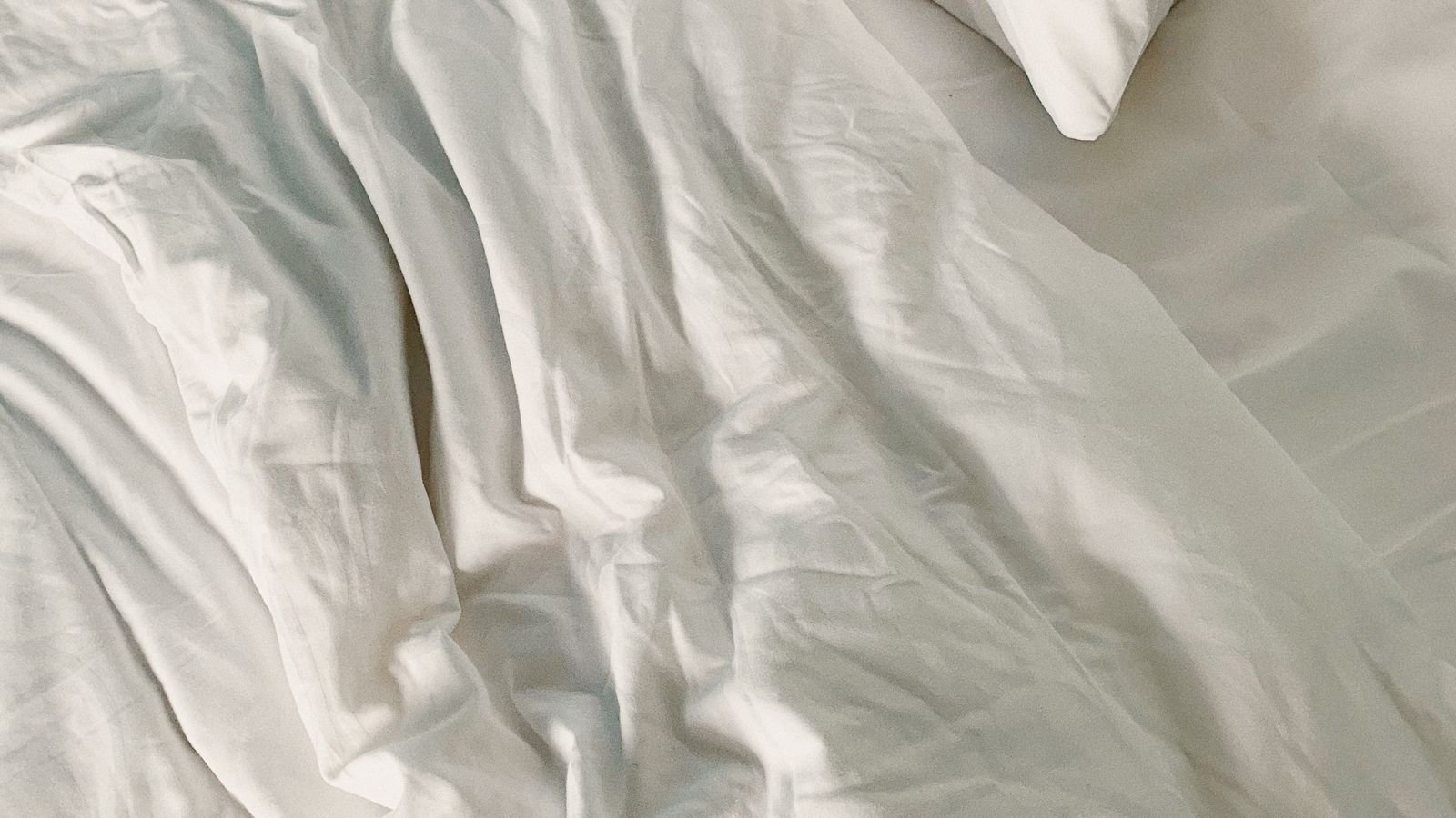 Close view of white bedding covering a bed. Close view of white bedding covering a bed.